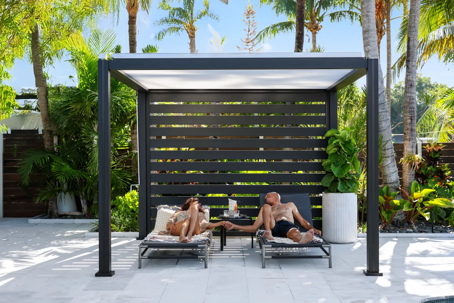 Azenco K-BANA freestanding louvered pergola with white louvers beside a pool