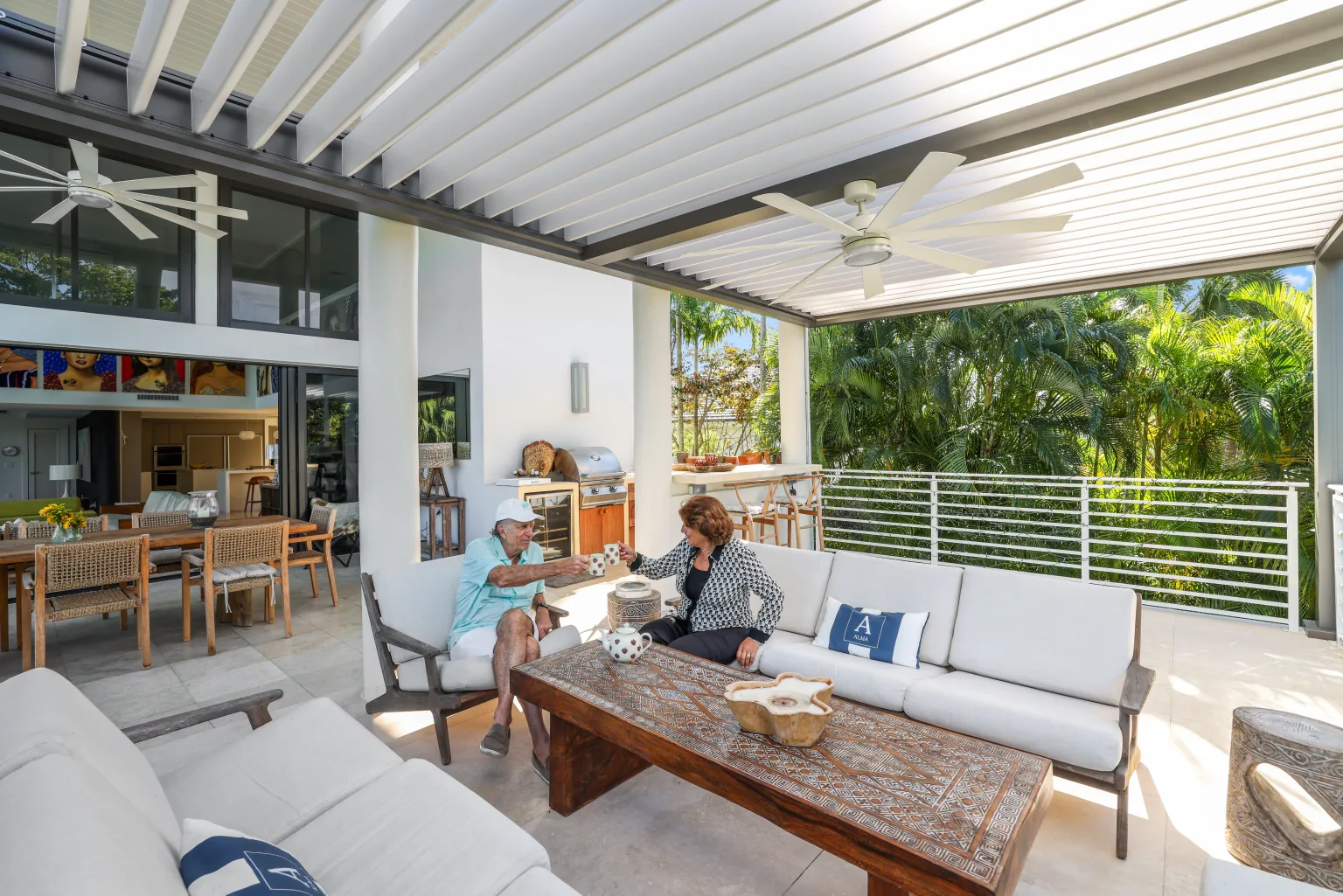 Azenco R-BLADE motorized louvered pergola with LED lighting beside a pool at dusk