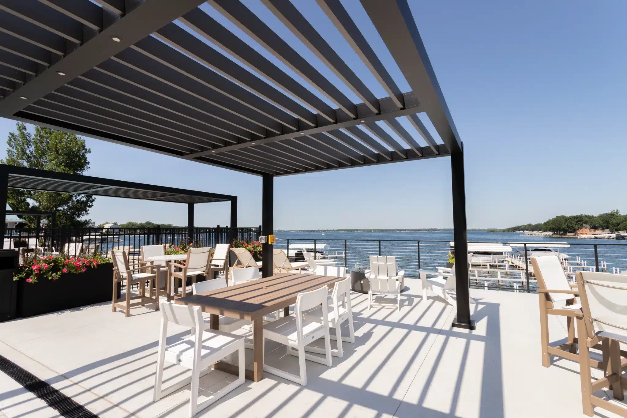 Azenco R-BREEZE fixed louvered pergola over an outdoor dining and pool area